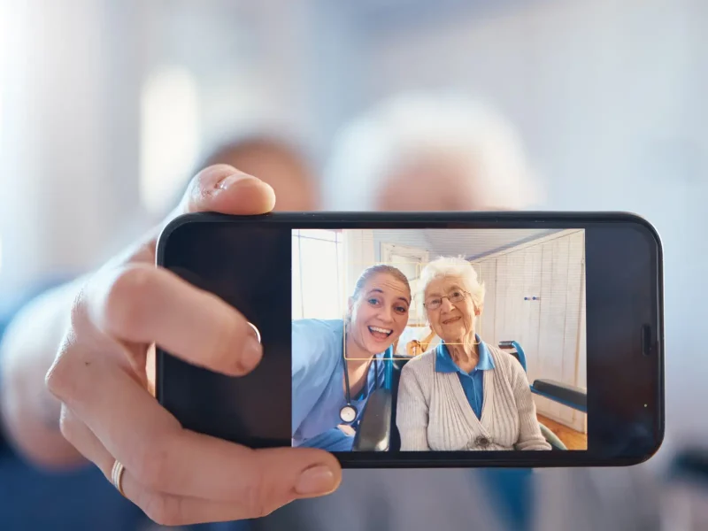 Phone, nurse and happy old woman take a selfie after a medical check and consulting with a doctor. .